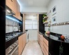 Moderna Cocina con muebles funcionales con cocina encimera de 4 platos horno, campana, cubierta de granito y lavaplatos de acero inoxidable.  doble